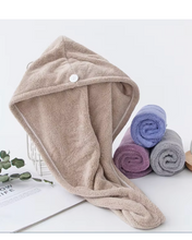 Load image into Gallery viewer, Beige hooded towel with rolled-up towels in the background on a white surface.
